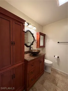 a bathroom with a granite countertop toilet sink and mirror