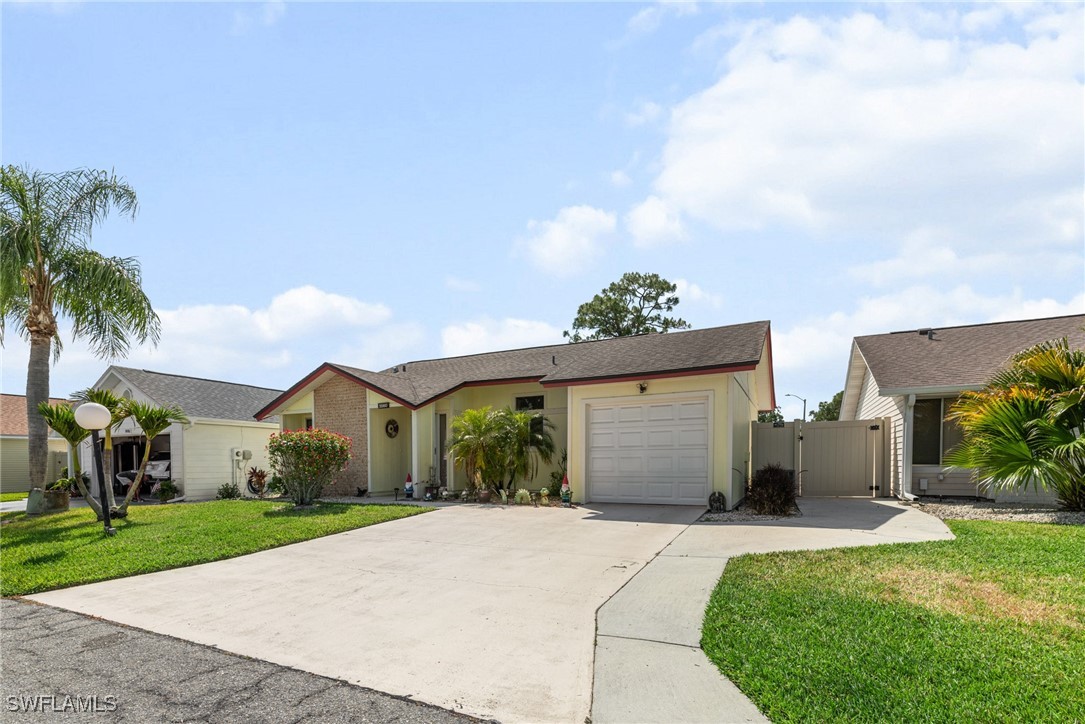 5560 Longleaf Drive North Fort Myers, FL 33917 - Photo 2 of 40 a front view of a house with a yard and garage