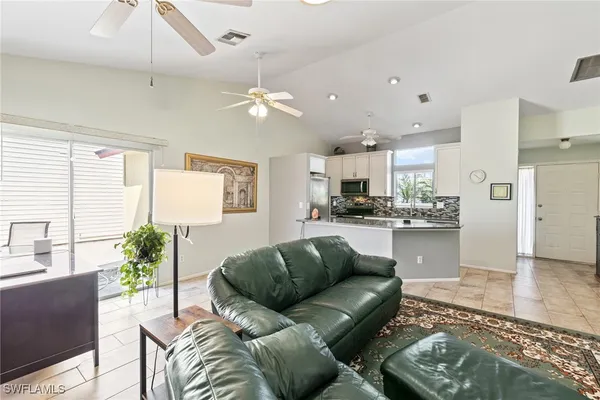a living room with stainless steel appliances kitchen island granite countertop furniture and a view of kitchen