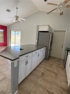 a kitchen with granite countertop white cabinets and white appliances