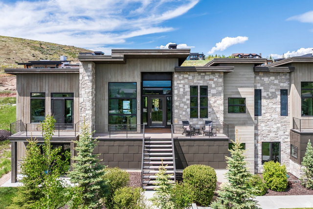 140 West Vista Road Kamas, UT 84036 - Photo 16 of 101 Modern architectural design with stone and wood panel exterior, multiple balconies with metal railings, and a prominent front entrance with full-light glass doors