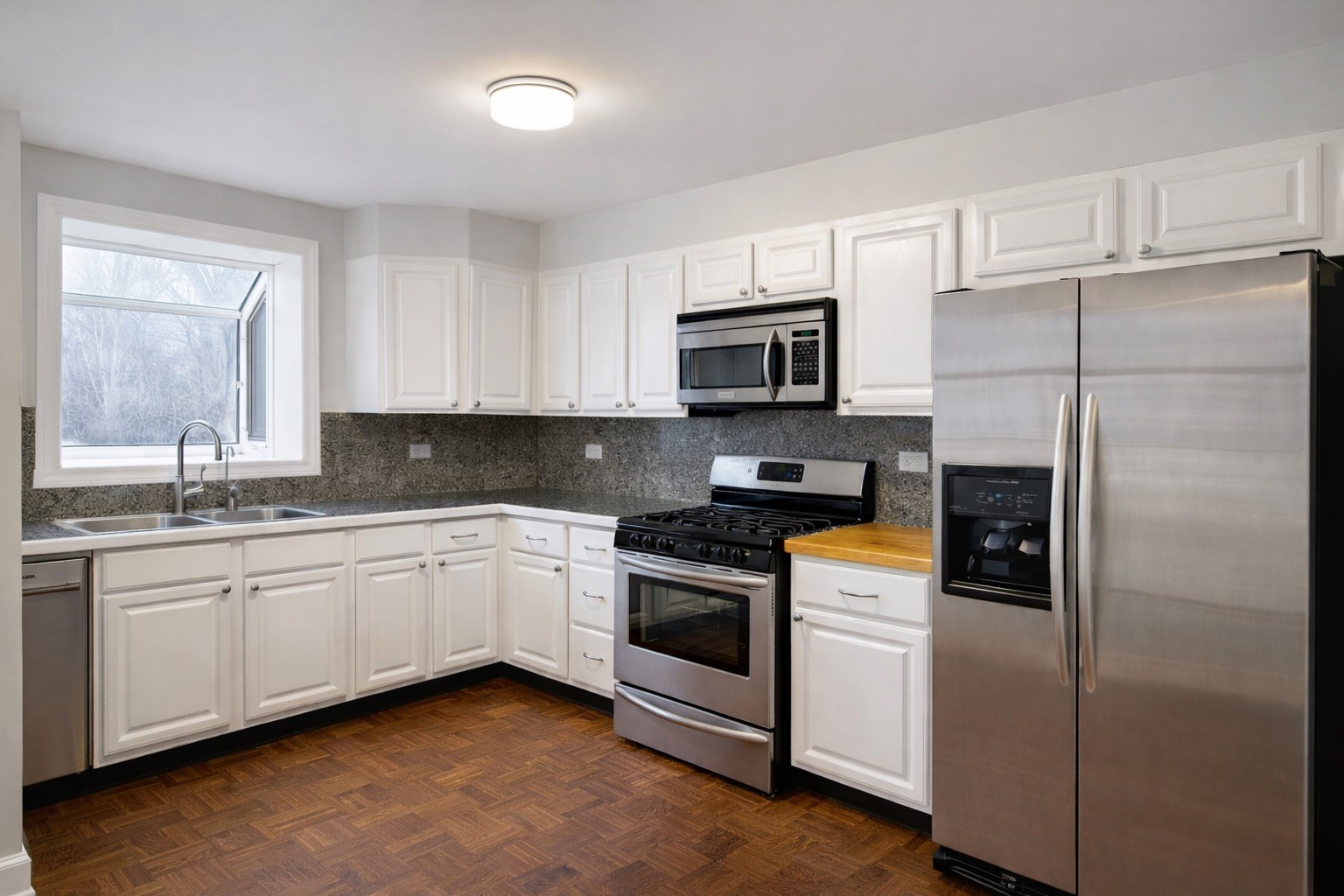 2727 Elgin Road Evanston, IL 60201 - Photo 5 of 11 a kitchen with granite countertop stainless steel appliances a refrigerator a sink a stove a microwave and cabinets