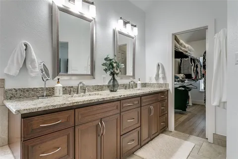 a bathroom with a granite countertop sink double vanity and a mirror