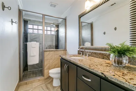 a bathroom with a granite countertop sink toilet and shower