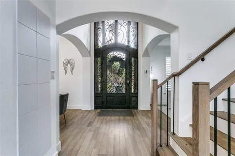 a view of a hallway with wooden floor and entryway