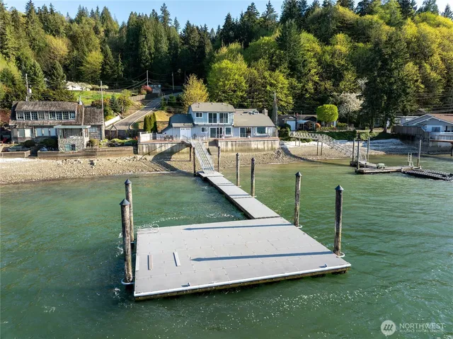 a view of a swimming pool with lawn chairs and plants