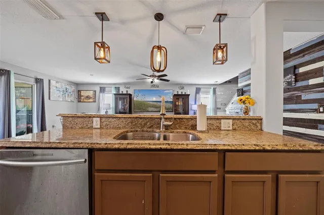 a kitchen with kitchen island granite countertop a sink a counter space appliances and cabinets