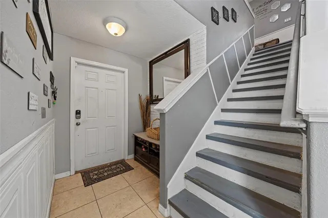 a view of staircase with white walls and lots of frames on wall