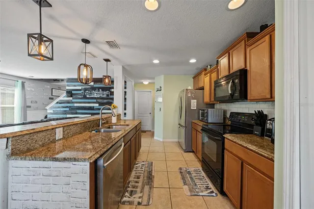 a kitchen with stainless steel appliances granite countertop a stove a sink and a microwave