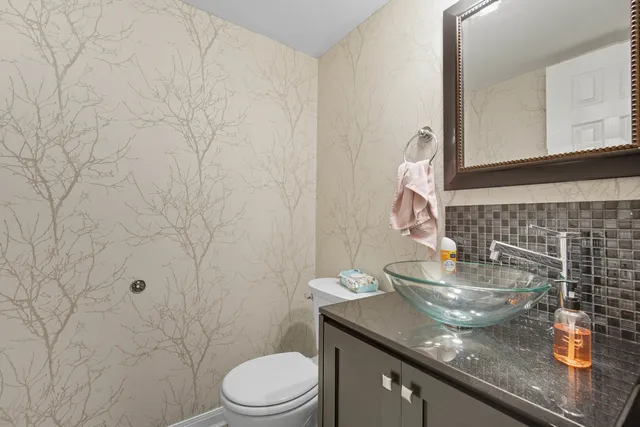 a bathroom with a granite countertop sink a toilet and mirror