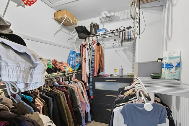 a view of walk in closet with clothes and shoes