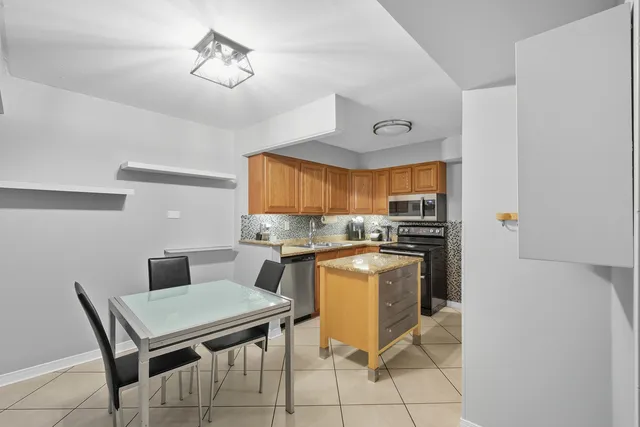 a kitchen with a stove a refrigerator and a dining table