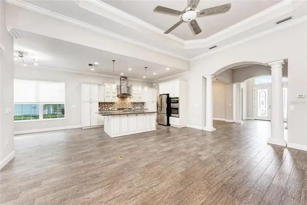 a large kitchen with stainless steel appliances kitchen island granite countertop a large counter top and wooden floors