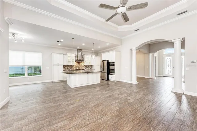 a large kitchen with stainless steel appliances kitchen island granite countertop a large counter top and wooden floors