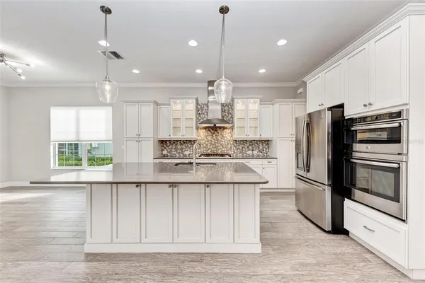 a kitchen with stainless steel appliances granite countertop a sink a stove and cabinets
