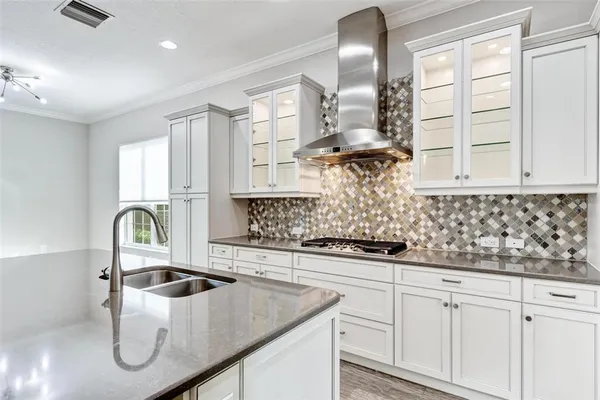 a kitchen with a sink stove and wooden floor