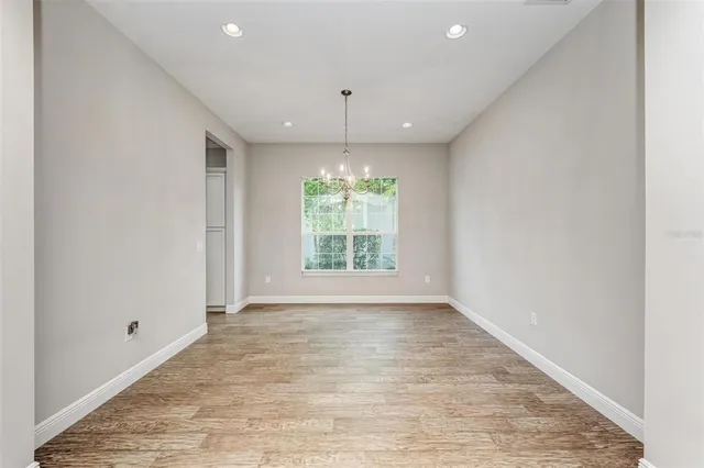 a view of a living room and a kitchen with wooden floor