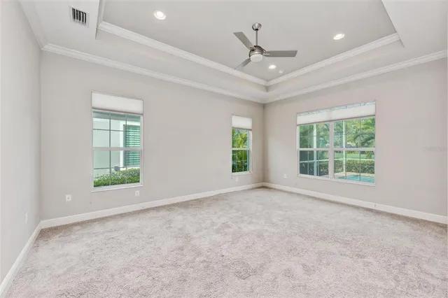 an empty room with windows and ceiling fan