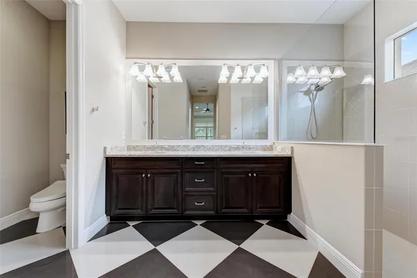 a bathroom with a granite countertop sink a large mirror and a shower