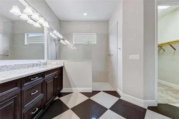 a bathroom with a granite countertop sink a large mirror and a shower