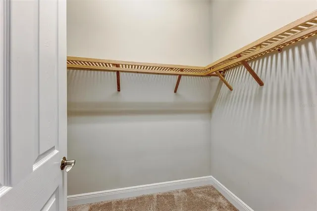 an empty room with a window and a ceiling fan