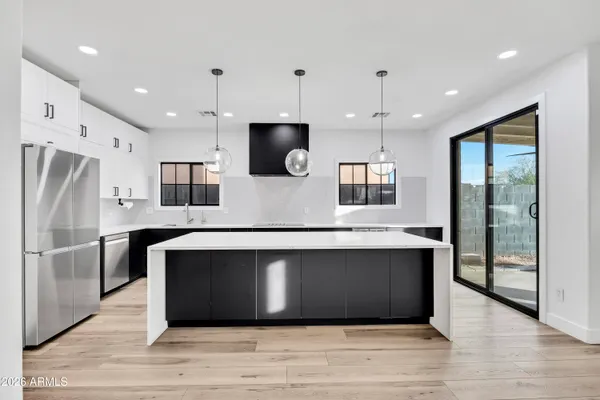 a large kitchen with stainless steel appliances granite countertop a refrigerator a stove a sink and a microwave