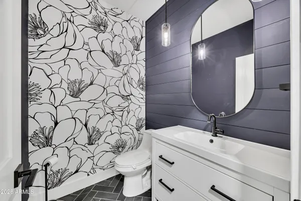 a bathroom with a sink and mirror with toilet