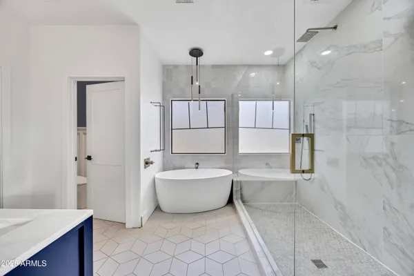 a spacious bathroom with a tub sink and mirror