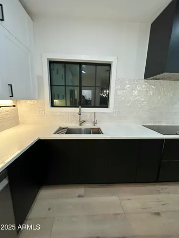 a large kitchen with a sink and a stove top oven