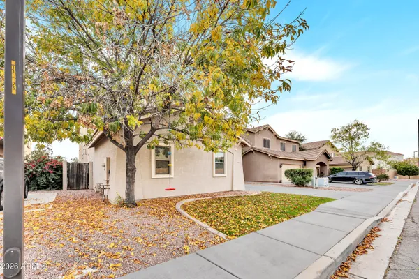 a view of a white house with a large tree