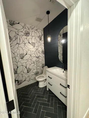 a view of an empty room with wooden floor and a fireplace