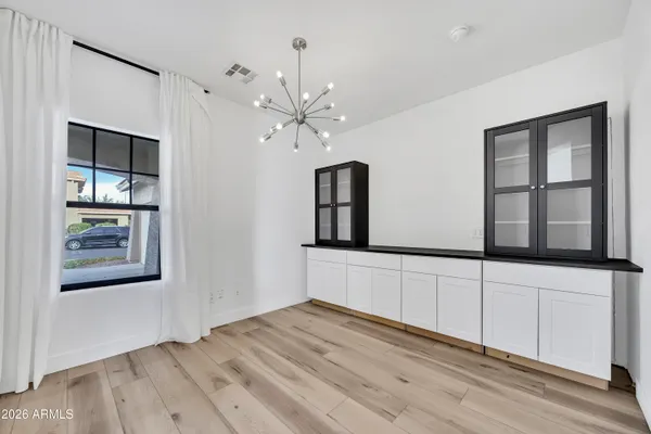 a view of an empty room with window and wooden floor