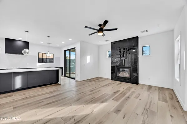 a living room with stainless steel appliances kitchen island furniture and wooden floor