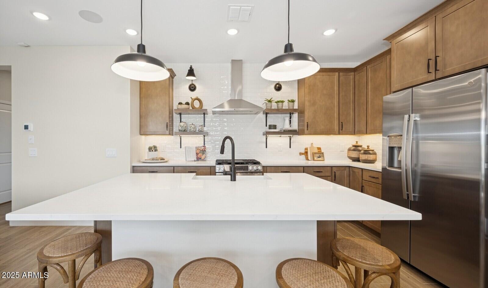 8026 West Royal Palm Road Peoria, AZ 85345 - Photo 6 of 37 a kitchen with stainless steel appliances a table chairs sink refrigerator and microwave