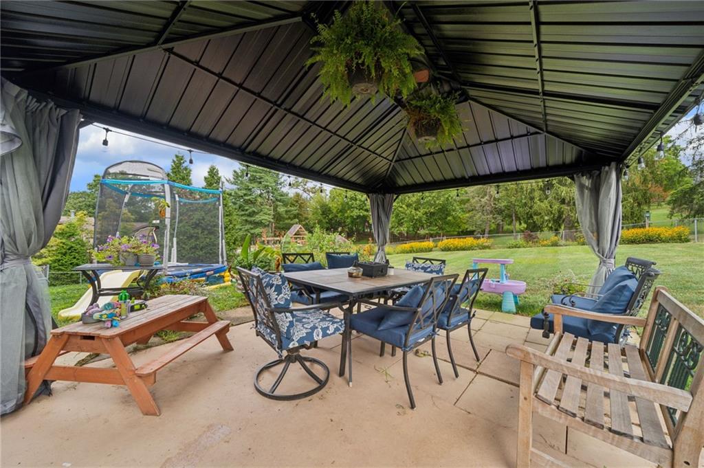 12629 Deborah Drive Irwin, PA 15642 - Photo 25 of 33 a view of patio with table and chairs under an umbrella with a small yard