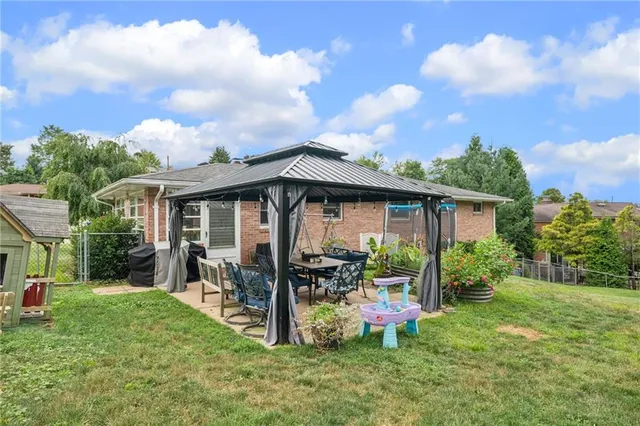 a view of a house with backyard sitting area and garden