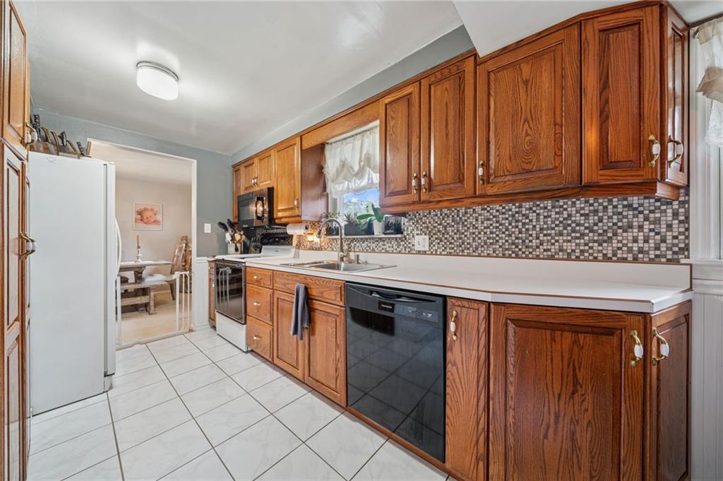 12629 Deborah Drive Irwin, PA 15642 - Photo 6 of 33 a kitchen with stainless steel appliances granite countertop a stove a sink dishwasher and a refrigerator with wooden cabinets