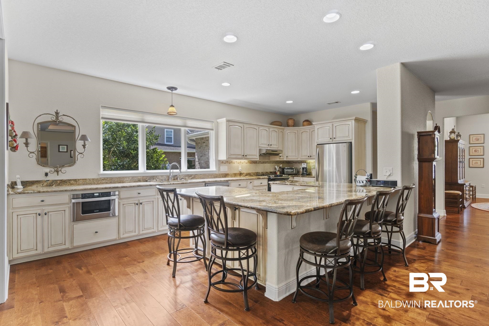 8664 Foxtail Loop Pensacola, FL 32526 - Photo 13 of 64 Kitchen featuring appliances with stainless steel finishes, a kitchen bar, light wood-style flooring, light stone countertops, and recessed lighting