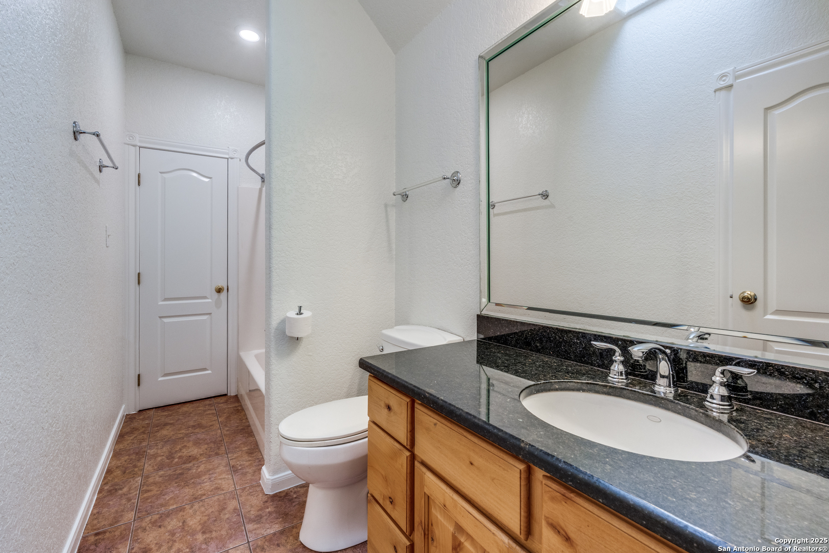 201 Yucca Canyon Spring Branch, TX 78070 - Photo 22 of 40 a bathroom with a granite countertop sink toilet a mirror and shower