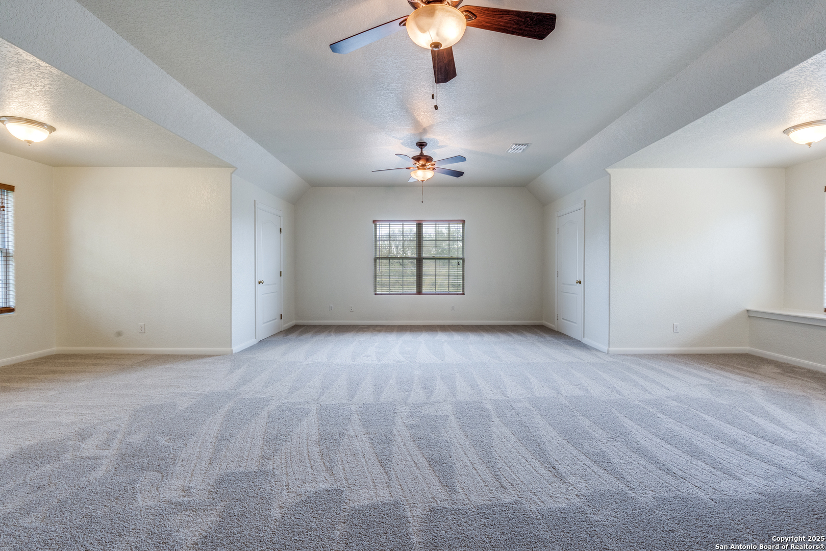 201 Yucca Canyon Spring Branch, TX 78070 - Photo 23 of 40 an empty room with wooden floor chandelier fan and windows