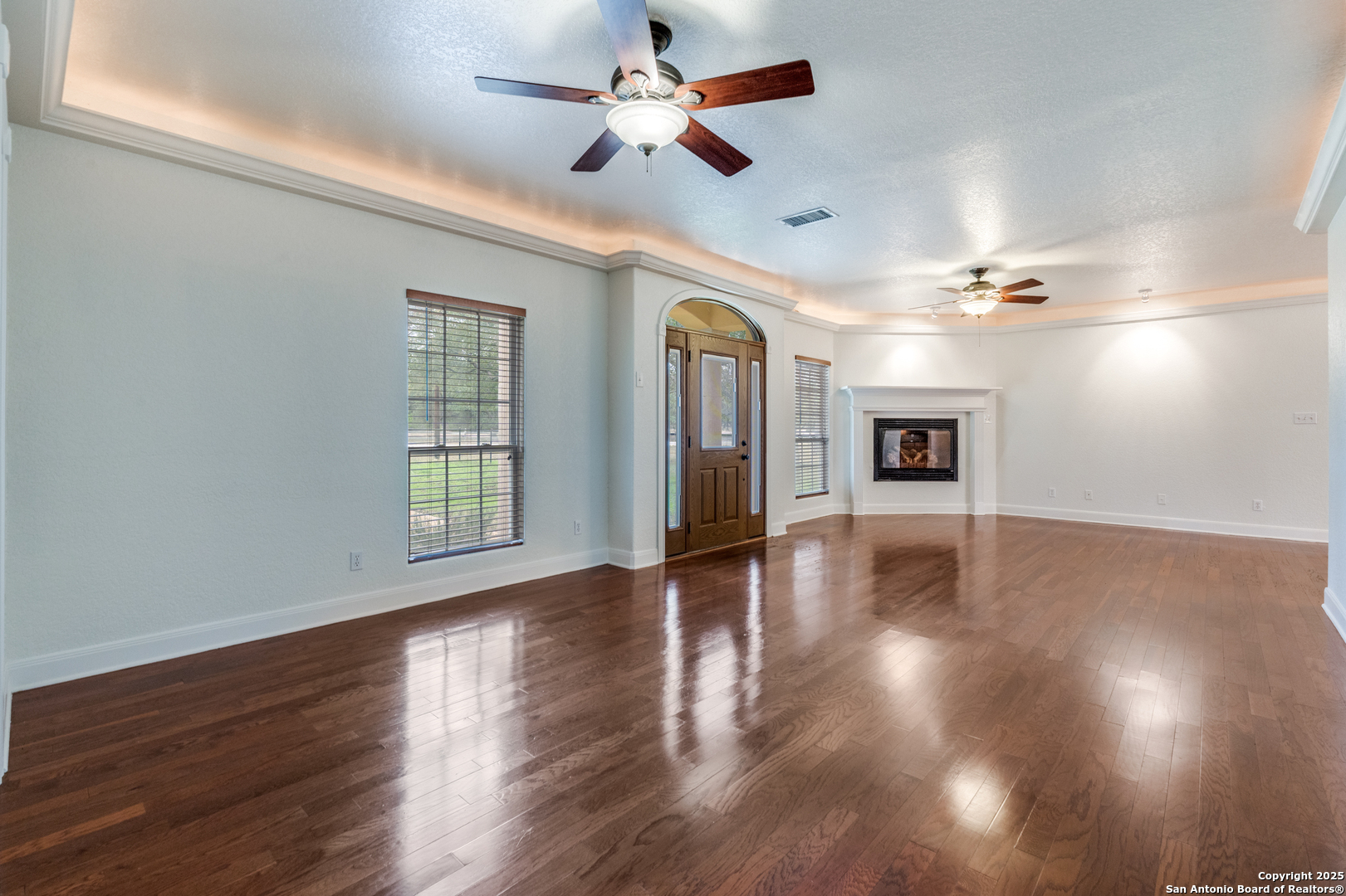 201 Yucca Canyon Spring Branch, TX 78070 - Photo 4 of 40 a view of a livingroom with wooden floor a ceiling fan and windows