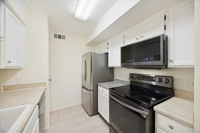 a kitchen with stainless steel appliances a stove a microwave and a refrigerator