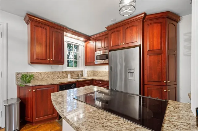 a kitchen with stainless steel appliances granite countertop a refrigerator a sink and dishwasher