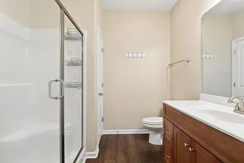 a bathroom with a sink a toilet a shower and a window