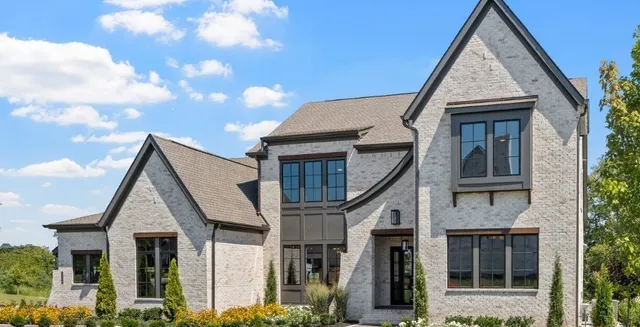 a view of a brick house many windows and wooden fence