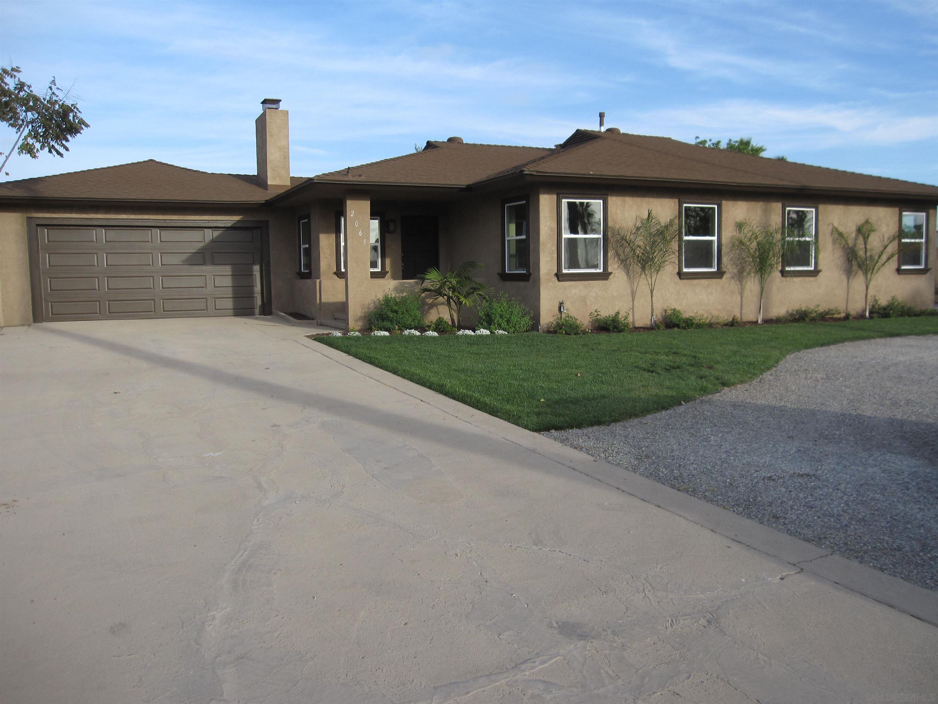 a front view of a house with a garden and plants