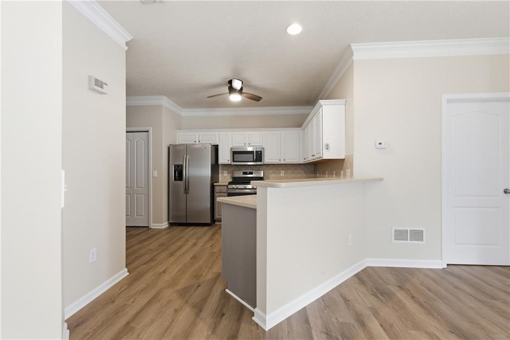 4533 Caleb Crossing, Unit 18 Powder Springs, GA 30127 - Photo 8 of 24 a kitchen with stainless steel appliances a refrigerator and a stove top oven