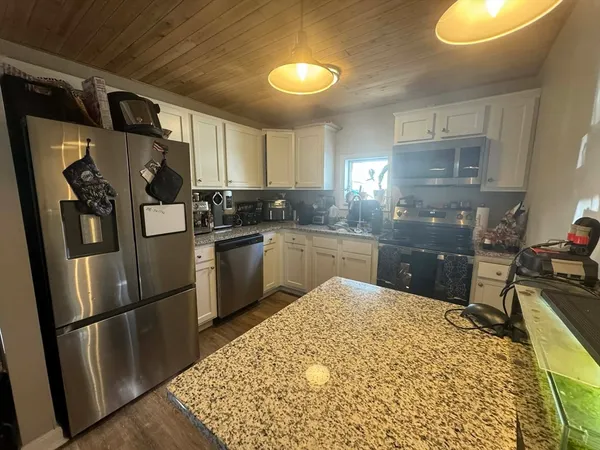 a kitchen with stainless steel appliances granite countertop a refrigerator sink and cabinets