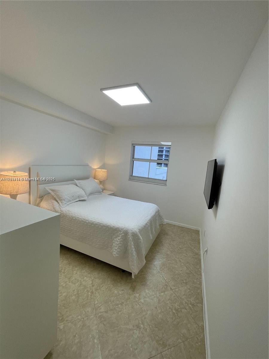 185 Southeast 14th Terrace, Unit 712 Miami, FL 33131 - Photo 3 of 9 a bedroom with a bed and a night stand