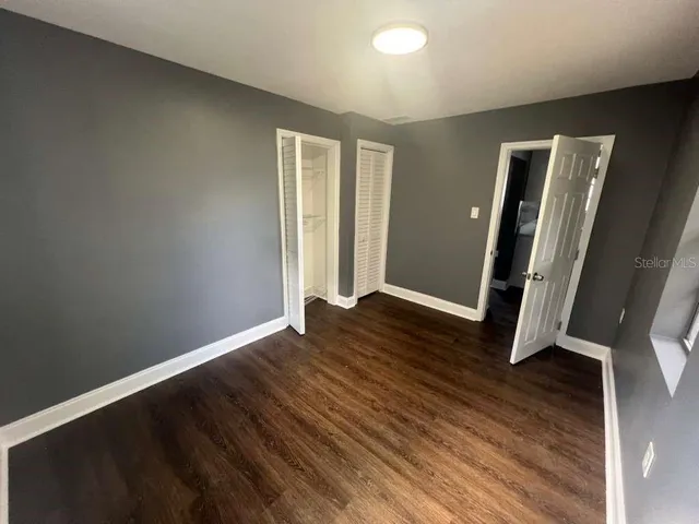 an empty room with wooden floor and window